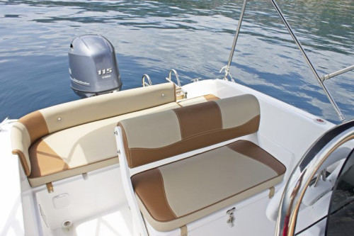Rear seating area of Syros 190 speedboat with cushioned bench and storage space